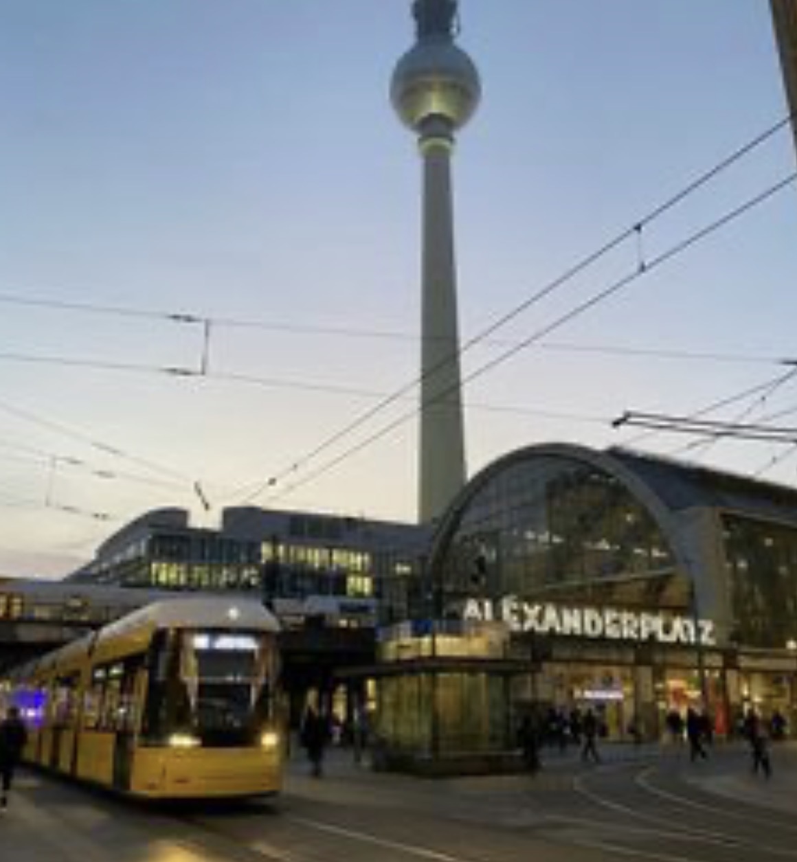 A yellow tram at Alexanderplatz with the TV Tower behind