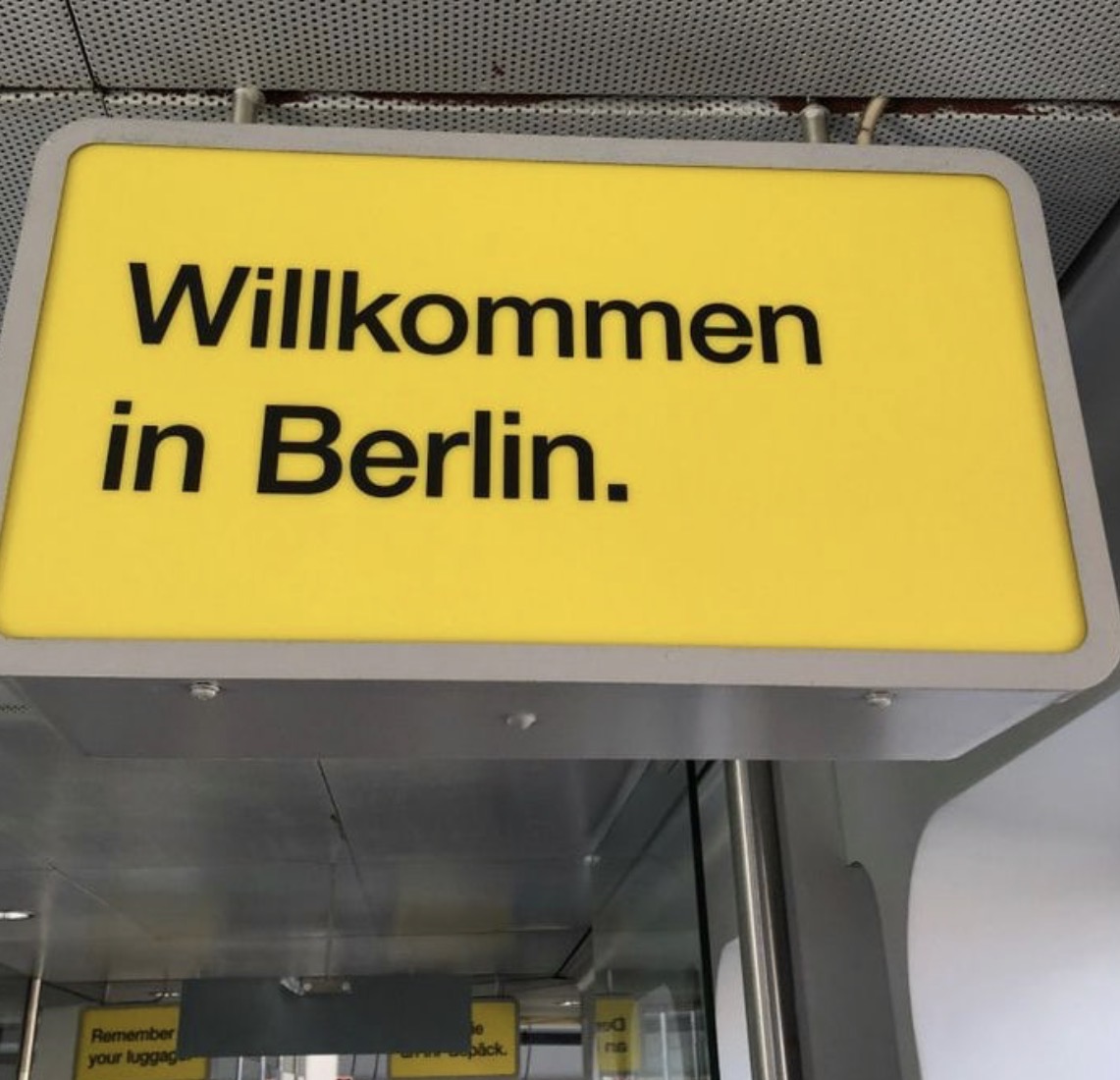 A yellow overhead sign reading Willkommen in Berlin