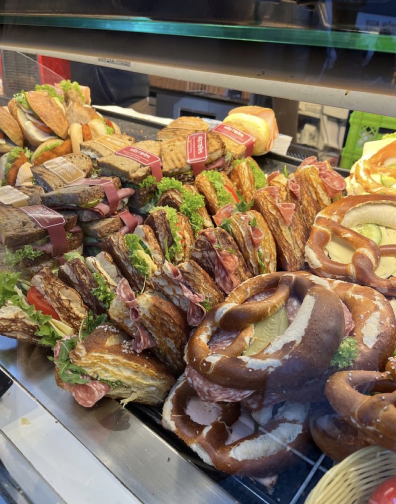 A deli counter with pretzel sandwiches and sliced meats