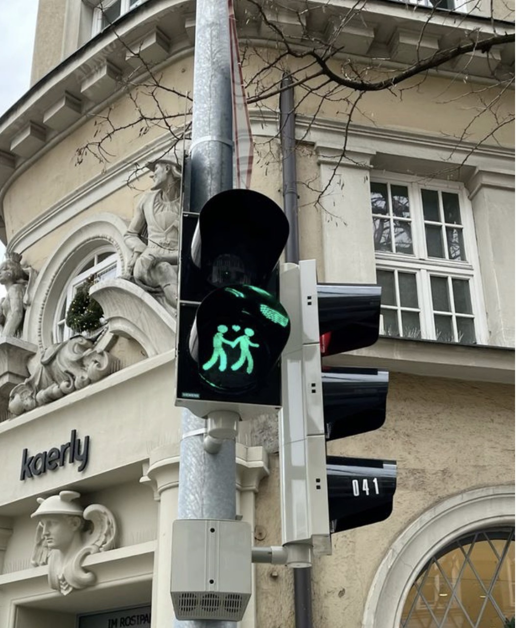 A green pedestrian light showing two people holding hands